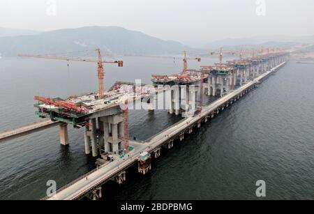 Zhengzhou. 9 avril 2020. La photo aérienne prise le 9 avril 2020 montre le chantier d'un pont de l'autoroute Mianchi-Yuanqu au-dessus de la rivière jaune, province du Henan au centre de la Chine. Le pont est une importante voie express interprovinciale reliant les provinces de Shanxi et de Henan, avec une longueur design de 1 757 mètres et une largeur de 33 mètres. Le projet devrait être achevé et ouvert au trafic d'ici la fin de 2020. Crédit: Zhu Xiang/Xinhua/Alay Live News Banque D'Images