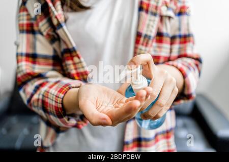 Jeune femme utilisant du gel anti-septique à main d'alcool pour nettoyer ses mains, prévention de la sécurité pendant l'éclosion du virus Corona, COVID-19 Banque D'Images