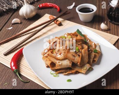 Nouilles Biang Biang servies avec de la poudre de Chili, de l'ail, des oignons de printemps et de la sauce soya Banque D'Images