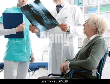 Médecin vérifiant l'image radiographique d'une patiente âgée au cours d'une visite à l'hôpital, concept de blessure et d'ostéoporose Banque D'Images