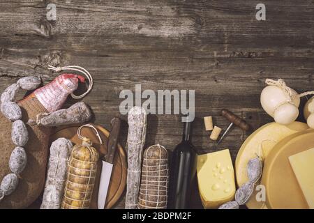 Cuisine gastronomique italienne traditionnelle et bouteille de vin rouge, assortiment de fromages et salami sur une table en bois rustique Banque D'Images