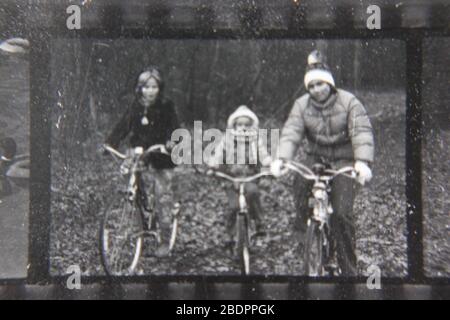 Belle photographie en noir et blanc vintage des années 1970 des enfants qui font du vélo dans les bois. Banque D'Images