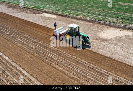 Wuzhong. 9 avril 2020. La photo aérienne prise le 9 avril 2020 montre un tracteur sans pilote avec système de navigation Beidou installé sur un champ de paddy dans une zone de démonstration agricole intelligente dans le village de Tawan, dans le district de Litong, dans la ville de Wuzhong, dans la région autonome de Ningxia hui, au nord-ouest de la Chine. Ces dernières années, l'autorité locale du district de Litong à Wuzhong City a intensifié ses efforts pour développer une agriculture intelligente, afin d'améliorer l'efficacité et de réduire le coût de production. Crédit: Feng Kaihua/Xinhua/Alay Live News Banque D'Images