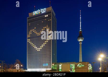 06.04.2020, le Park Inn by Radisson Hotel sur Alexanderplatz à Berlin, comme tous les autres hôtels pour le moment, ne sera peut-être pas ouvert pour des opérations régulières en raison de la crise de la couronne. Cependant, il y a encore peu de fonctionnement. Par conséquent, un coeur est actuellement montré sur la façade par un éclairage partiel des fenêtres, ce qui devrait exprimer la solidarité. | utilisation dans le monde entier Banque D'Images