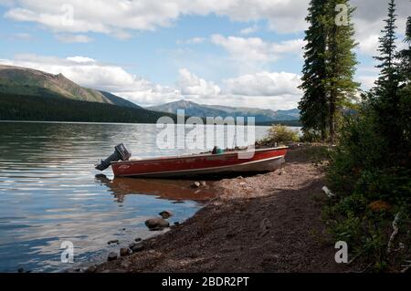 Un petit bateau à moteur est situé sur la rive du lac Cold Fish, dans le parc provincial Wilderness du plateau de Spatsizi, en Colombie-Britannique, au Canada. Banque D'Images