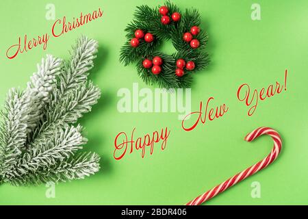 Fêtes de Noël et nouvel an carte de souhaits avec Canne de Noël arc rouge et couronne de Noël sur fond vert. Banque D'Images