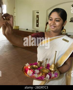 Une fille indienne en tenue traditionnelle saluant les clients de l'hôtel Brunton Boatyard, fort Kochi, Kochi, Kerala, Inde Banque D'Images