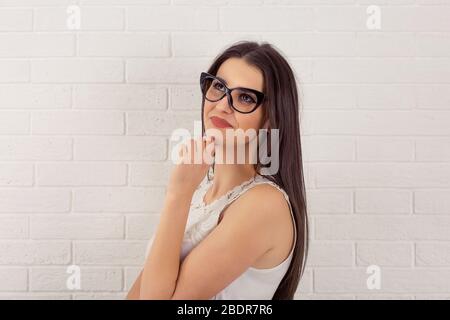 Réflexion. Gros plan portrait tête tourné mixte course rêvant sourire mignon confiante brunette femme d'affaires femme d'affaires isolé briques blanches backgroun Banque D'Images