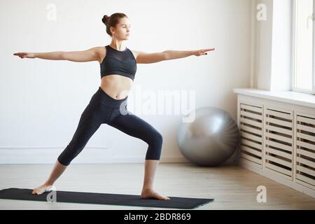 Jeune femme en bonne santé debout sur un tapis d'exercice et s'exerçant dans un club de santé Banque D'Images