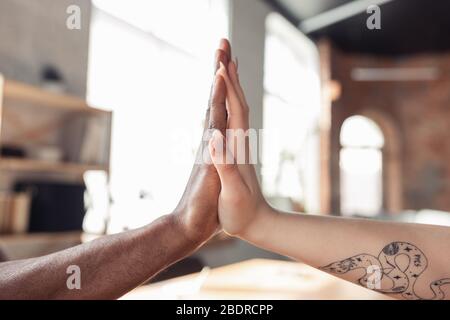 Teambuilding, travail d'équipe, amitié. Gros plan sur les mains des hommes afro-américains et des femmes caucasiennes. Concept d'affaires, de finances, d'emploi. CopySpace pour la publicité. Éducation, communication et freelance. Banque D'Images