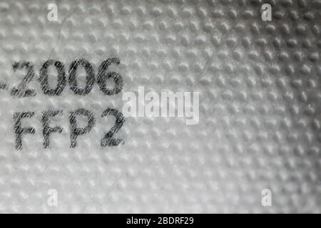 Macro et faible profondeur de champ (mise au point sélective) avec la texture et les inscriptions d'un masque visage et nez anti covid-19 ffp2. Banque D'Images