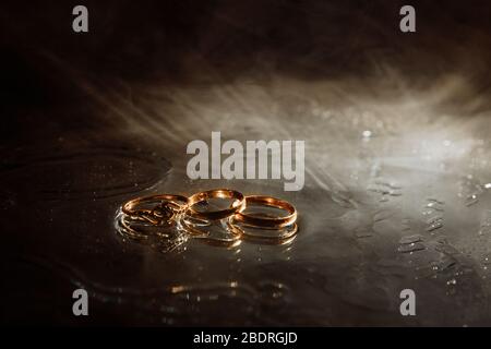 Les caractères de la famille. Trois anneaux dorés se trouvent côte à côte. 2 bagues de mariage et 1 bague d'engagement. Banque D'Images