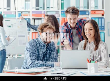 Les jeunes de l'équipe d'affaires de discuter d'un projet et d'une connexion avec un ordinateur portable, le démarrage et l'équipe concept Banque D'Images