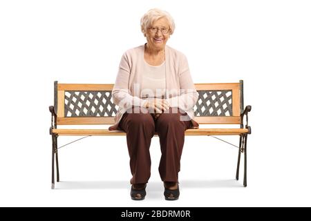 Femme senior assise sur un banc et souriant à la caméra isolée sur fond blanc Banque D'Images