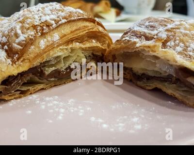 Délicieux croissant français avec remplissage au chocolat et sucre en poudre sur le dessus Banque D'Images