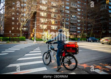 Un liveur avec un tote de marque DoorDash sur sa bicyclette dans le quartier de Chelsea à New York le lundi 6 avril 2020. (© Richard B. Levine) Banque D'Images