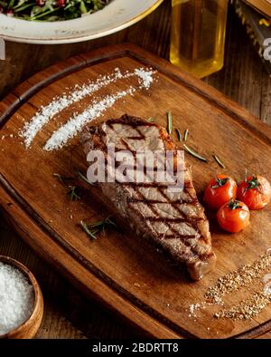 bifteck grillé servi avec des herbes salines et des tomates grillées Banque D'Images