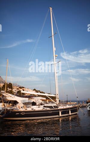 yacht à voile dans le port d'une petite ville, illuminée par le soleil couchant. photos de virage vintage Banque D'Images