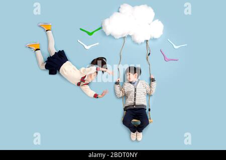 Joyeux swing des enfants dans les nuages Banque D'Images