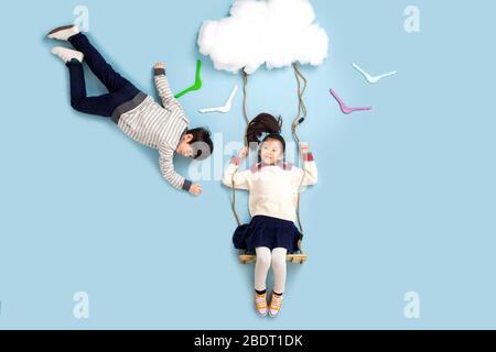 Joyeux swing des enfants dans les nuages Banque D'Images