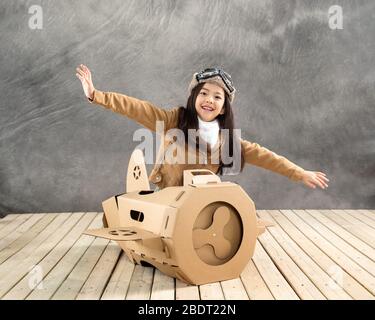 Avion en papier conduisant des enfants heureux Banque D'Images