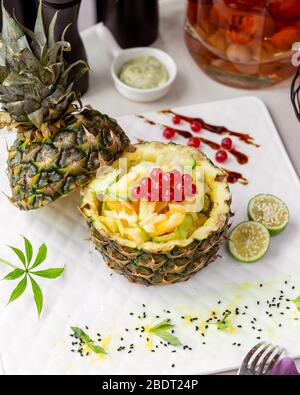gros plan sur le bol d'ananas avec du currant rouge de concombre d'orange et de l'ananas Banque D'Images
