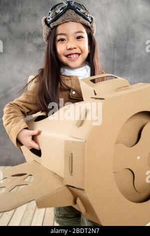 Avion en papier conduisant des enfants heureux Banque D'Images