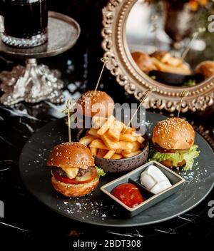 trois mini-hamburgers servis avec des frites de tomates et de mayonnaise Banque D'Images