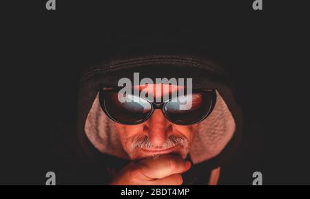 portrait de l'homme mûr devant le moniteur d'ordinateur. L'image d'écran reflétée dans les lunettes de soleil Banque D'Images
