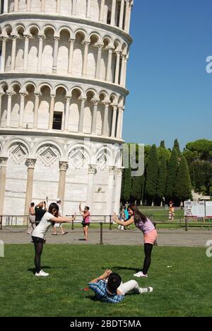 Pise, Italie - septembre 2011: Les touristes posant sur l'herbe pour des photos devant la tour penchée de Pise Banque D'Images