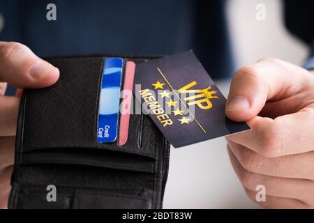 Gros plan de la main d'UNE personne retrait de la carte de membre VIP du portefeuille Banque D'Images