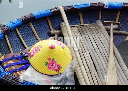 les vietnames traditionnels de chapeau de bambou dans un bateau rond traditionnel de bambou Banque D'Images