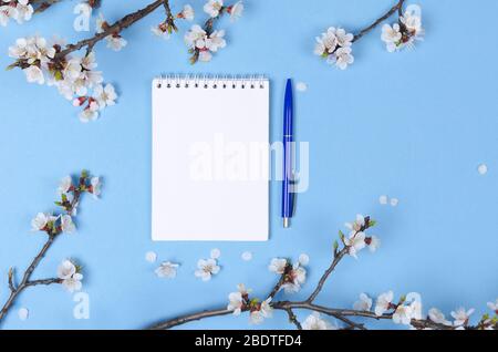 Liste de souhaits pour les plans futurs. composition de la couche plate avec fleurs et bloc-notes Banque D'Images