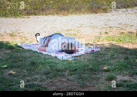 Concept de détente, auto-éducation.UN homme reposant sur l'herbe sur une journée d'été ensoleillée. Un homme dormait sur l'herbe, un homme allongé dans l'herbe et le rel Banque D'Images