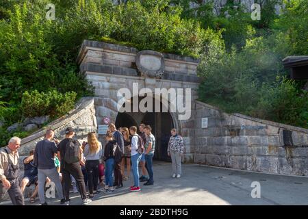 Les gens qui se tiennent à côté du tunnel d'entrée menant à l'ascenseur jusqu'à l'Eagle's Nest, Berchtesgaden, Bavière, Allemagne. Banque D'Images