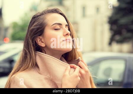 Femme heureuse et insouciante regardant profiter du soleil sur son visage. Détente en profitant de la nature coucher de soleil lever de soleil isolé ville urbaine arrière-plan. Concept de liberté. Enj Banque D'Images