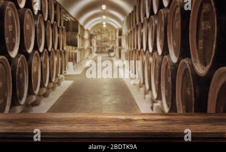 Table en bois vide avec fond flou de fûts de vin dans la cave à vin. Concept de cave de vinification et de boissons. Rendu 3D-Illustration. Banque D'Images