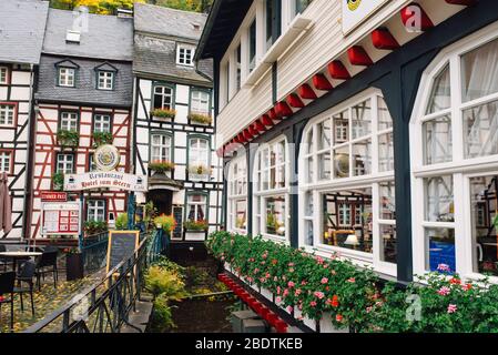 Maisons à colombages le long de la rivière Ruhr à Monschau, Eifel, en journée nuageux Banque D'Images