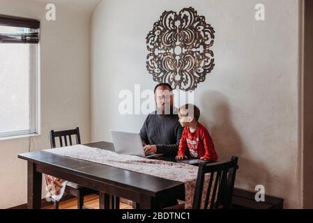 Vue panoramique sur le père qui tente de travailler de chez lui avec un tout-petit debout Banque D'Images