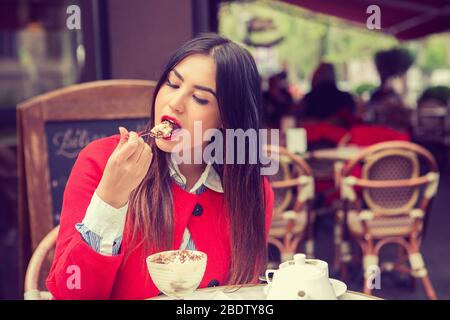 Femme dans un restaurant qui profite de sa glace à gâteau dans le désert Banque D'Images