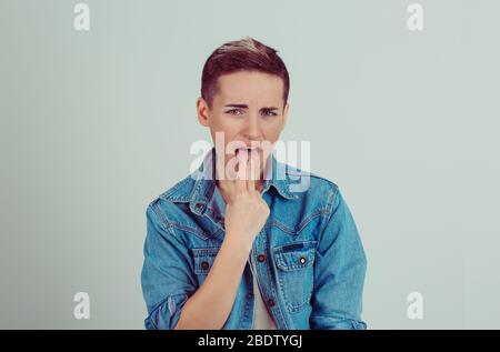 Gros plan portrait jeune malade mécontent, le doigt dans la gorge, sur le point de jeter le puke vert gris blanc fond. Expr. Visage émotion négative Banque D'Images