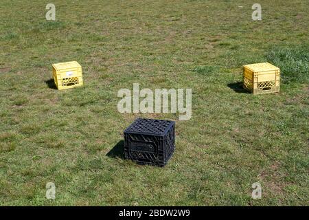 Vancouver, Canada, le 09 avril 2020. Les récipients de stockage de lait en plastique se séparent de six pieds servent de sièges pour les personnes qui suivent des règles de distanciation sociale pendant la pandémie de COVD-19. Banque D'Images