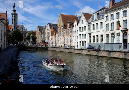 Tour en bateau sur le canal de Spiegelrei avec la place Jan Van Eyckplein et la tour de Poortersloge (Burgherss' Lodge) en arrière-plan.Bruges.Flandre Occidentale.Belgique Banque D'Images