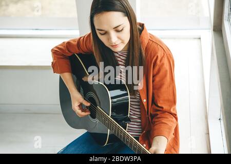 Apprendre à jouer de la guitare. Le professeur explique à l'élève les bases de la guitare. Cours individuels à domicile ou cours extrascolaires. Banque D'Images