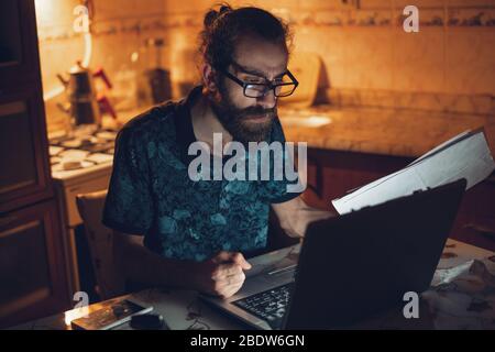 Un homme barbu de cheveux longs et de jeunes hipsters stressés vérifie la facture dans la cuisine.facture et finance. Banque D'Images