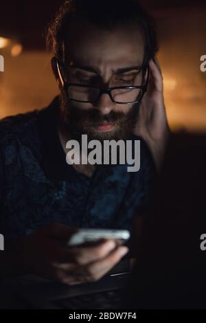 Un homme barbu de cheveux longs et de jeunes hipsters stressés vérifie la facture dans la cuisine.facture et finance. Banque D'Images