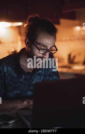 Un homme barbu de cheveux longs et de jeunes hipsters stressés vérifie la facture dans la cuisine.facture et finance. Banque D'Images