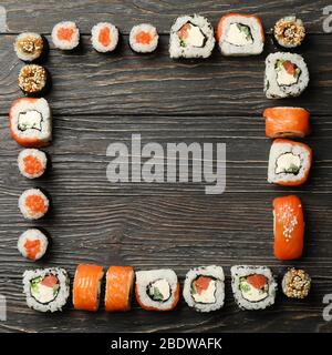 Plat avec des rouleaux de sushi sur fond en bois. Cuisine japonaise Banque D'Images