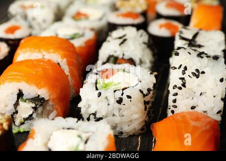 Délicieux petits pains à sushi sur fond de bois, gros plan de la cuisine japonaise Banque D'Images