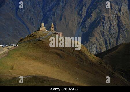 Église de Gergeti Trinity contre fond de roche. Cette ancienne église est située au fond de la montagne Kazbek (Géorgie). Banque D'Images